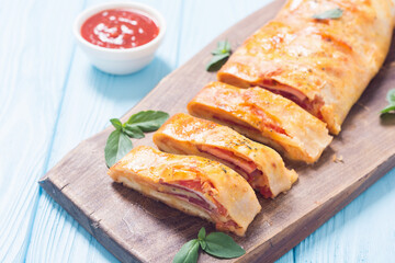 Pizza roll stromboli with cheese salami olives and tomatoes