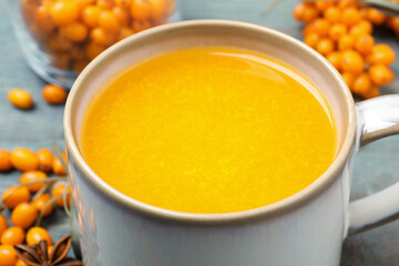 Fresh sea buckthorn tea on table, closeup