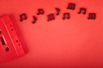 retro cassette tape with wooden notes on red background