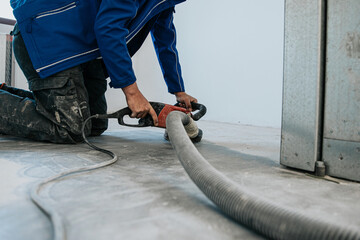 Construction worker using machine polishing surface floor smoothing and finishing hardener or epoxy...