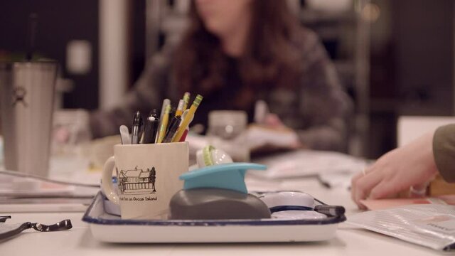 Craft supplies with woman working in the background