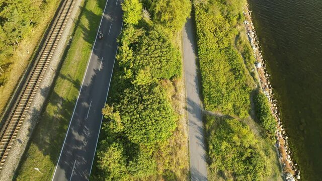 Highway road, railroad, and walking pedestrian path in Kuznica tourist spot in Hel Peninsula, Poland, baltic sea, Slow revealing shot by tilting the camera up