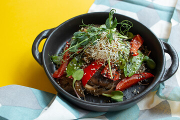 Close-up view of healthy meal with mushrooms, red peppers, micro green and sesame