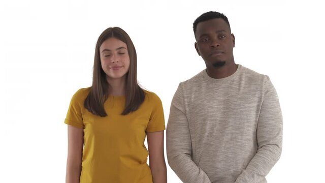 Portrait of mixed race couple shrugging shoulders expressing uncertainty and misunderstanding. Body language concept. Isolated on white background