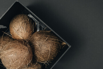 pile of coconuts, tropical fruits on black background