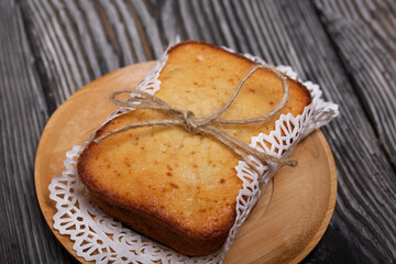 Freshly baked cupcake on a napkin. Tied with twine. Against the background of black pine boards.