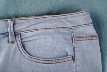 A pocket of blue jeans close-up on a blue sweater