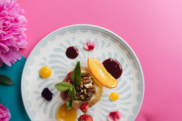 Baked apple stuffed with nuts and honey macro. Healthy meal, pink and blue background