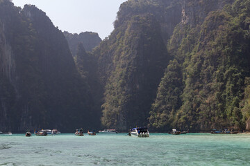 sea bay with boats against the backdrop of high green mountains