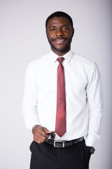 An african american man stands in a white shirt and with sunglasses in his hands on a white background