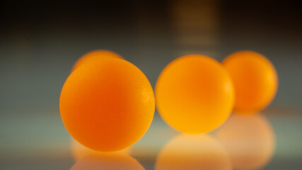 Orange balls on a dark reflective surface.