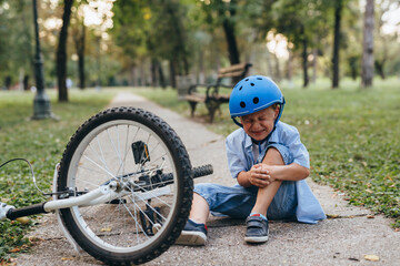 boy fall from the bike and crying in the park