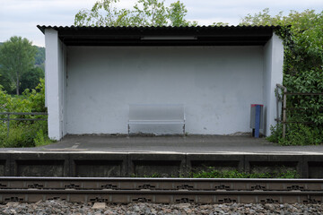 Wartehäuschen mit Sitzbank und Abfalleimer an Bahnsteig - Stockfoto