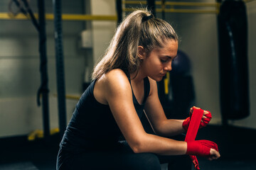 woman wrapping boxing bandages indoor