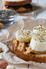 fast food, snack, two sandwiches with peanut butter jam and bananas on a white wooden table