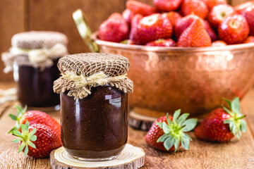 jar of Brazilian strawberry jam, with copper jar in the background with fresh and organic strawberries
