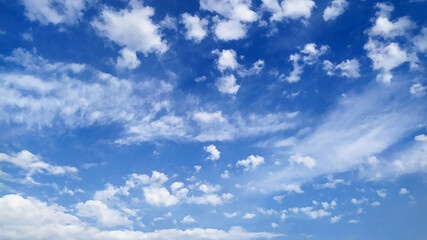 Beautiful blue sky with small white cumulus and large cirrus clouds as natural background