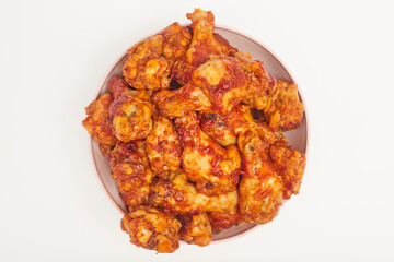 Buffalo chicken wings in a plate on a white background, copy space