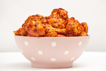 Buffalo chicken wings in a plate on a white background, copy space