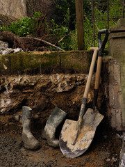 a pair of wellington boots and some spades