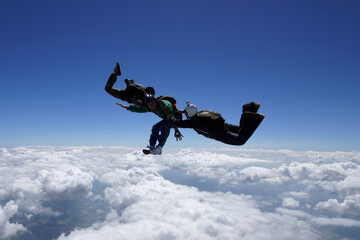 A pair of skydiving instructors try to hold a student out of control