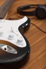 electric guitar on a wood table. headphones in background