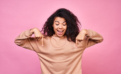 Young happy girl shows her thumbs down in surprise.