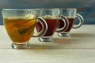 Three cups of red tea, green tea and black tea