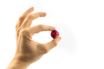 Precious red stone in judging hand on white isolated background