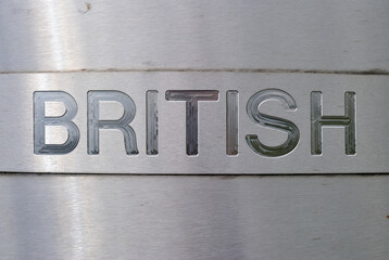 Close Up of Engraved Sign 'British' on Stainless Steel Plate 