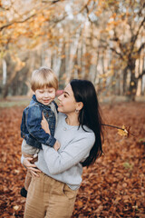 Mother with her little son in autumn park