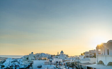Fototapeta na wymiar Panoramic view of Oia town in Santorini island with old whitewashed houses and traditional windmill, Greece. Greek landscape at sunset