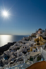 View of Oia town in Santorini island with old whitewashed houses and traditional windmill, Greece. Greek landscape on a sunny day. portrait format