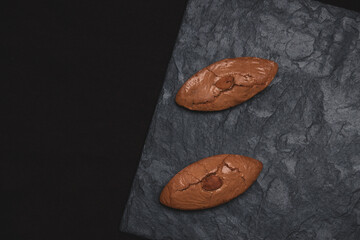 Two almond biscuits on a stone slab. Tasty food