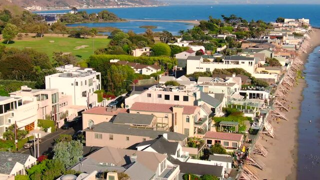 4K Aerial drone shot of Malibu Beach coastline in California with the blue Pacific Ocean with waves coming in and beach with nice houses on the background