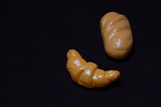 Toy bato and eclair on a dark background.