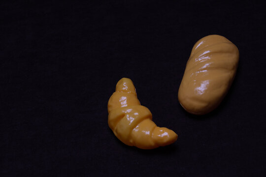 Toy bato and eclair on a dark background.