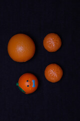 A set of toy oranges on a dark background. Plastic toy