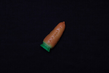 Toy carrot on a dark background.