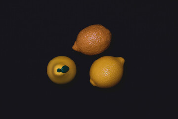 Photos of toy fruits on a dark background. Plastic toy