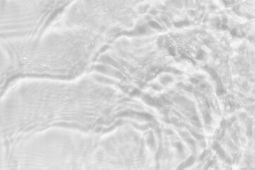 Fototapeta na wymiar White texture of light-shadow pattern of sunlight reflection from calm and rippled water surface. Beautiful natural pattern with 3D feeling. White-grey water waves.