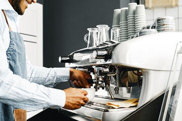 Unrecognizable man barista preparing coffee on professional coffee machine