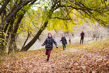 Twin brothers run in forest with mother