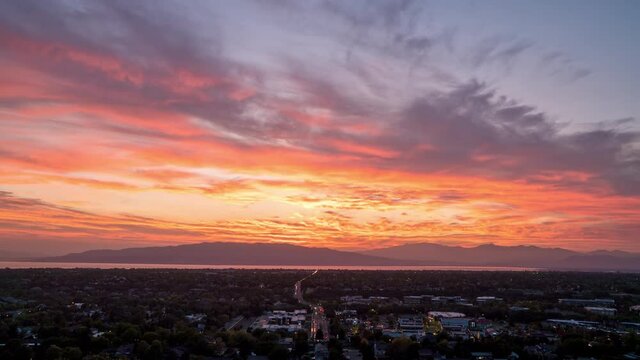 Sunset time lapse over traffic moving in Utah Valley as lights slowly turn on.