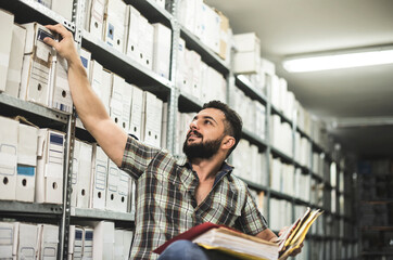 Man works in archive and reviews the different files