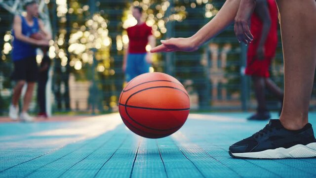 Close-up of sportswoman bouncing basketball ball training on ground floor of the court. Basketball player. Workout. Sport activities. Entertainment.