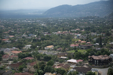 wide high angle shot of a town's buildings and houses with a mountain line and hazy sky in the background