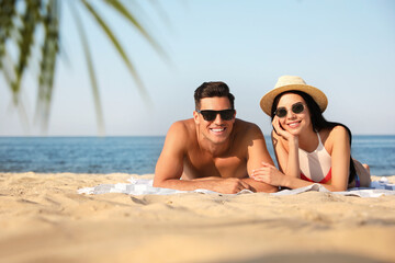 Obraz premium Happy couple resting on sunny beach. Space for text