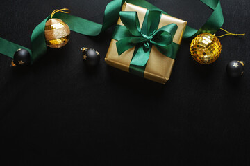Wrapped gift with baubles on dark background