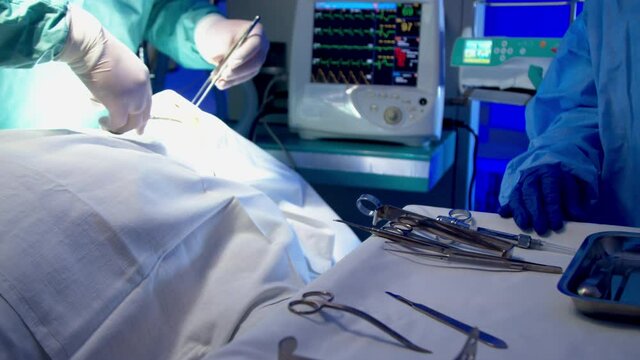 Nurse providing surgeon with tools during surgery